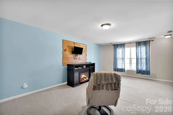a living room with furniture a flat screen tv and a window