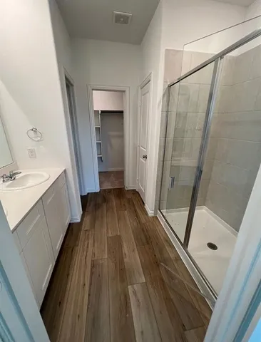 a bathroom with a sink a toilet a mirror and shower