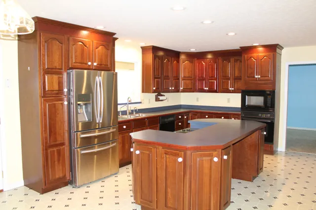 a kitchen with stainless steel appliances granite countertop a sink a refrigerator and a stove