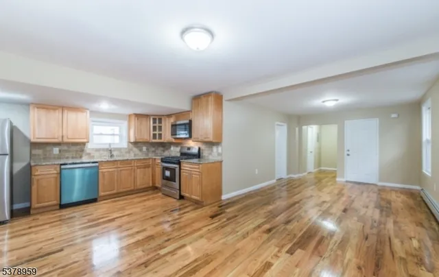 a kitchen with stainless steel appliances granite countertop a sink refrigerator and cabinets