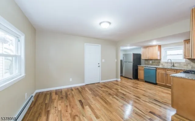 a view of a kitchen with granite countertop cabinets stainless steel appliances a sink and a window
