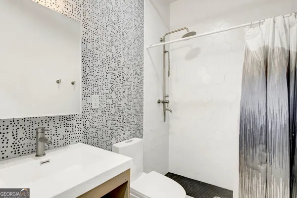 a bathroom with a sink toilet and shower