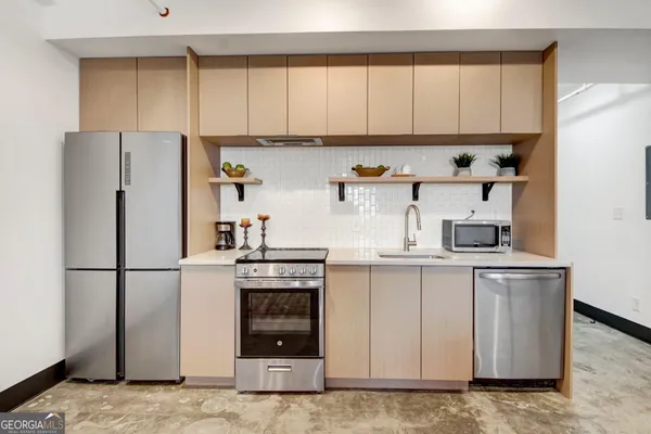 a kitchen with stainless steel appliances granite countertop a refrigerator sink and stove