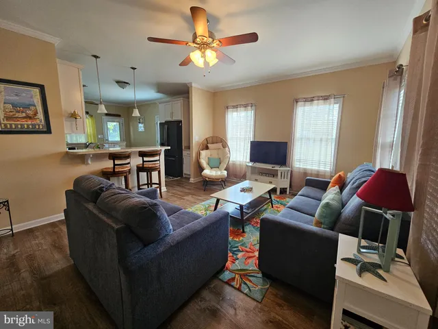 a living room with furniture a chandelier and a flat screen tv