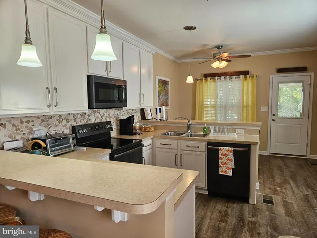 a kitchen with a stove a sink a microwave a dining table and chairs