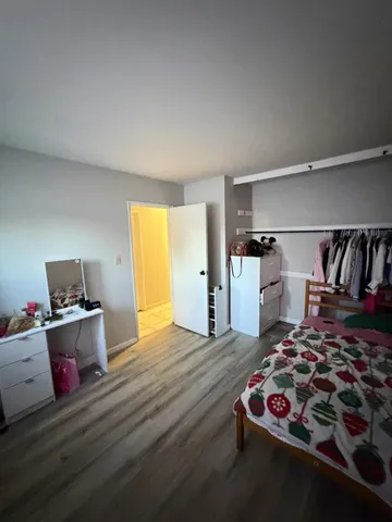 a bedroom with a bed and wooden floor