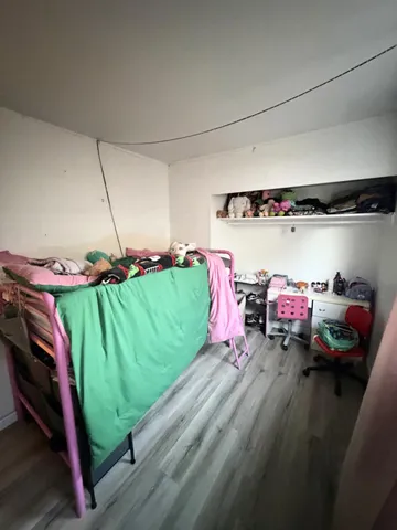 a living room with a bed a couch and potted plant