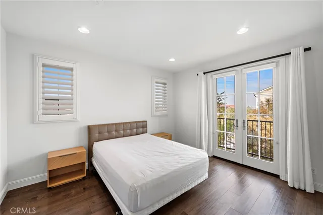 a bedroom with a large bed and wooden floor