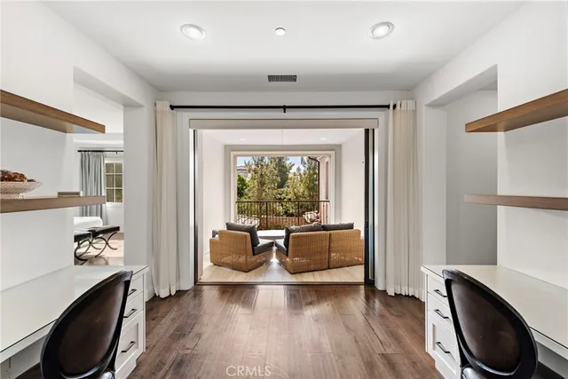 a view of a workspace with furniture and a window