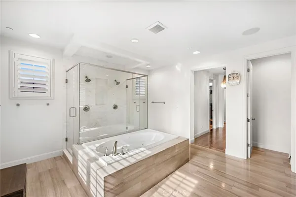 a spacious bathroom with a granite countertop sink a shower and a mirror