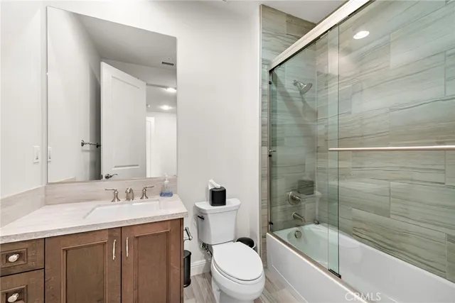 a bathroom with a bathtub shower sink mirror vanity and toilet