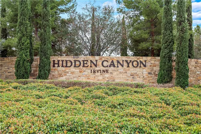 a sign of golf club on a wall under a tree