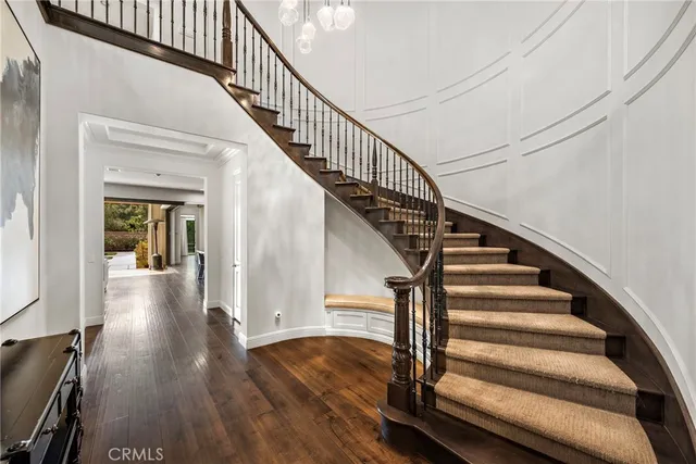 a view of staircase with wooden floor and white walls