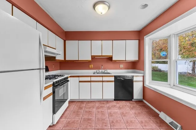 a kitchen with granite countertop sink stove and cabinets