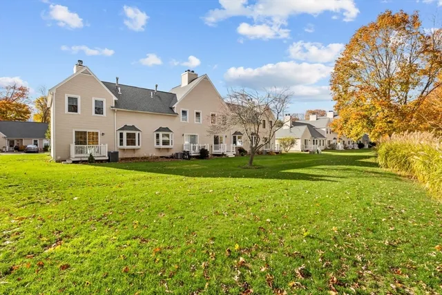 a front view of a house with a garden and trees