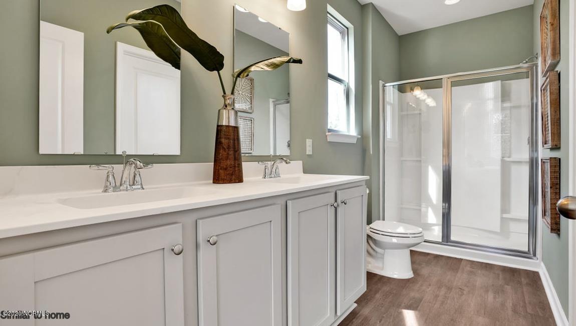 9067 St George Road, Unit LOT 34 Wilmington, NC 28411 - Photo 19 of 57 The owner's bath has a walk in shower with a glass shower door. the double vanity with cultured marble bowls
