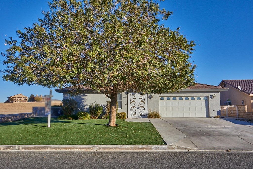 14790 Rivers Edge Road Helendale, CA 92342 - Photo 1 of 1 a front view of a house with a yard and a garage