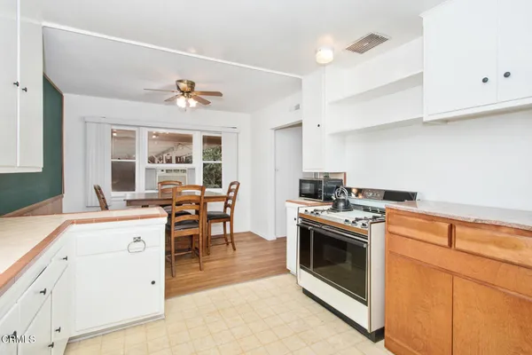 a kitchen with a stove top oven sink and cabinets