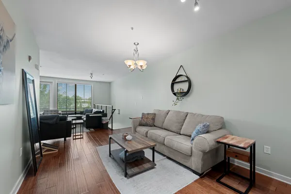 a living room with furniture a rug and a floor to ceiling window