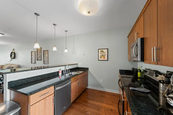 a kitchen with stainless steel appliances granite countertop a stove a sink and a refrigerator