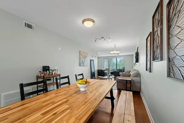 a living room with furniture chandelier and wooden floor