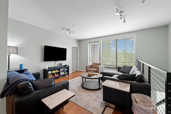 a kitchen with stainless steel appliances granite countertop a stove a refrigerator a sink a dining table and chairs with wooden floor
