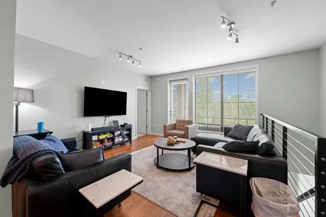 a kitchen with stainless steel appliances granite countertop a stove a refrigerator a sink a dining table and chairs with wooden floor