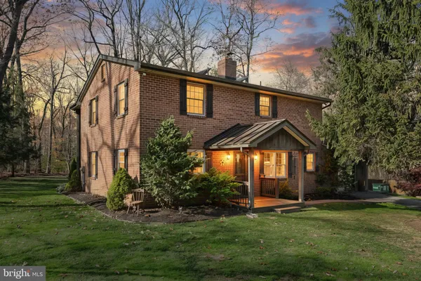 a backyard of a house with plants and large tree