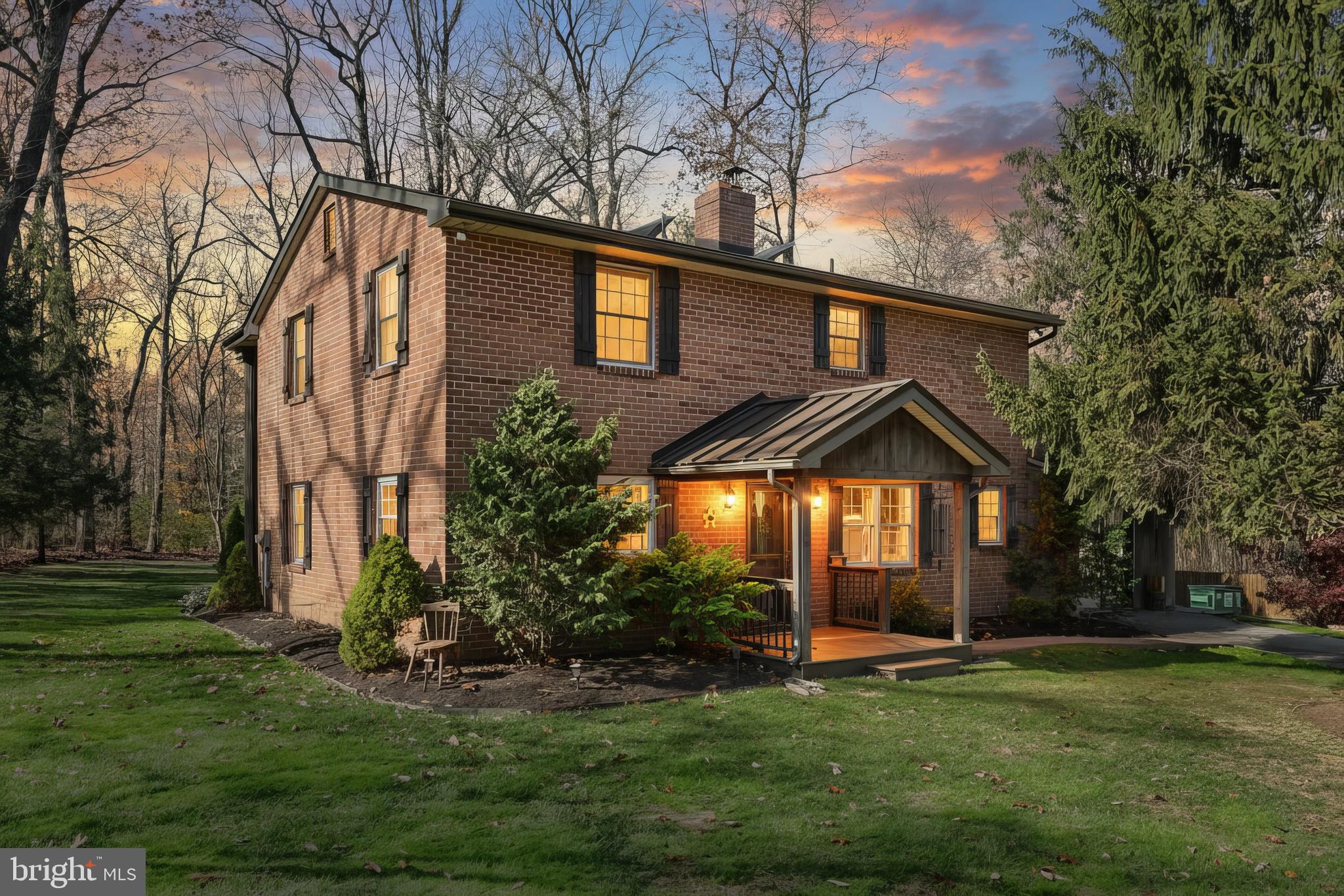 a backyard of a house with plants and large tree