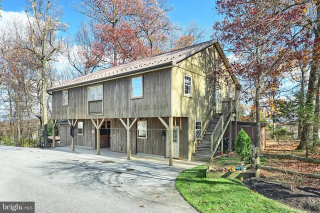 a backyard of a house with large trees and plants