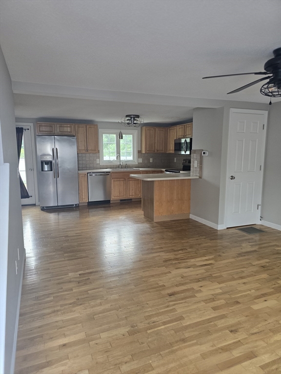 89 Belanger Street, Unit 89 Three Rivers, MA 01080 - Photo 2 of 19 a view of kitchen and empty room with wooden floor