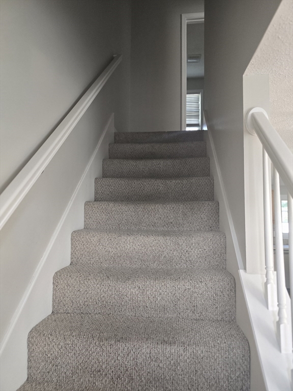 89 Belanger Street, Unit 89 Three Rivers, MA 01080 - Photo 8 of 19 a view of staircase with lots of frames on wall