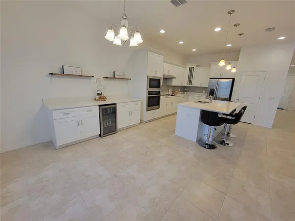 a kitchen with cabinets and chairs