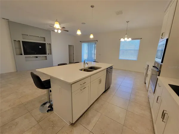 a kitchen with a sink a counter top space cabinets and stainless steel appliances