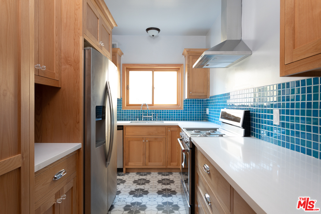 3009 Virginia Road Los Angeles, CA 90016 - Photo 4 of 8 a kitchen with stainless steel appliances granite countertop a sink a stove and a refrigerator