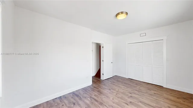 a view of a room with wooden floor and window