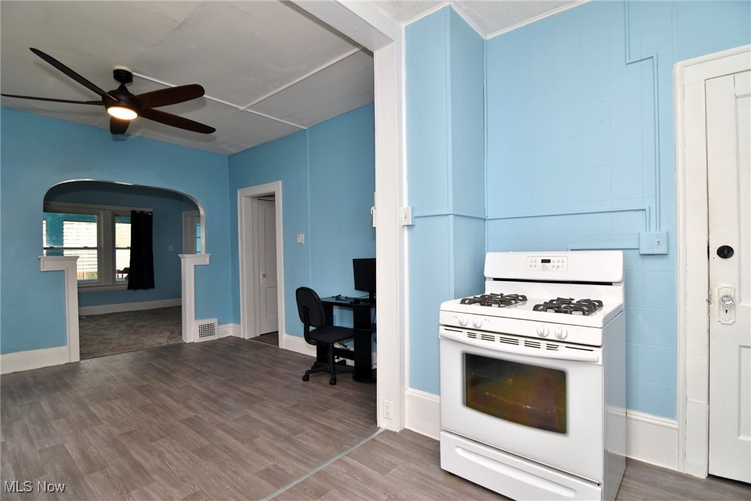 4213 Valley Road Cleveland, OH 44109 - Photo 14 of 47 Kitchen with visible vents, white range with gas cooktop, a ceiling fan, and wood finished floors