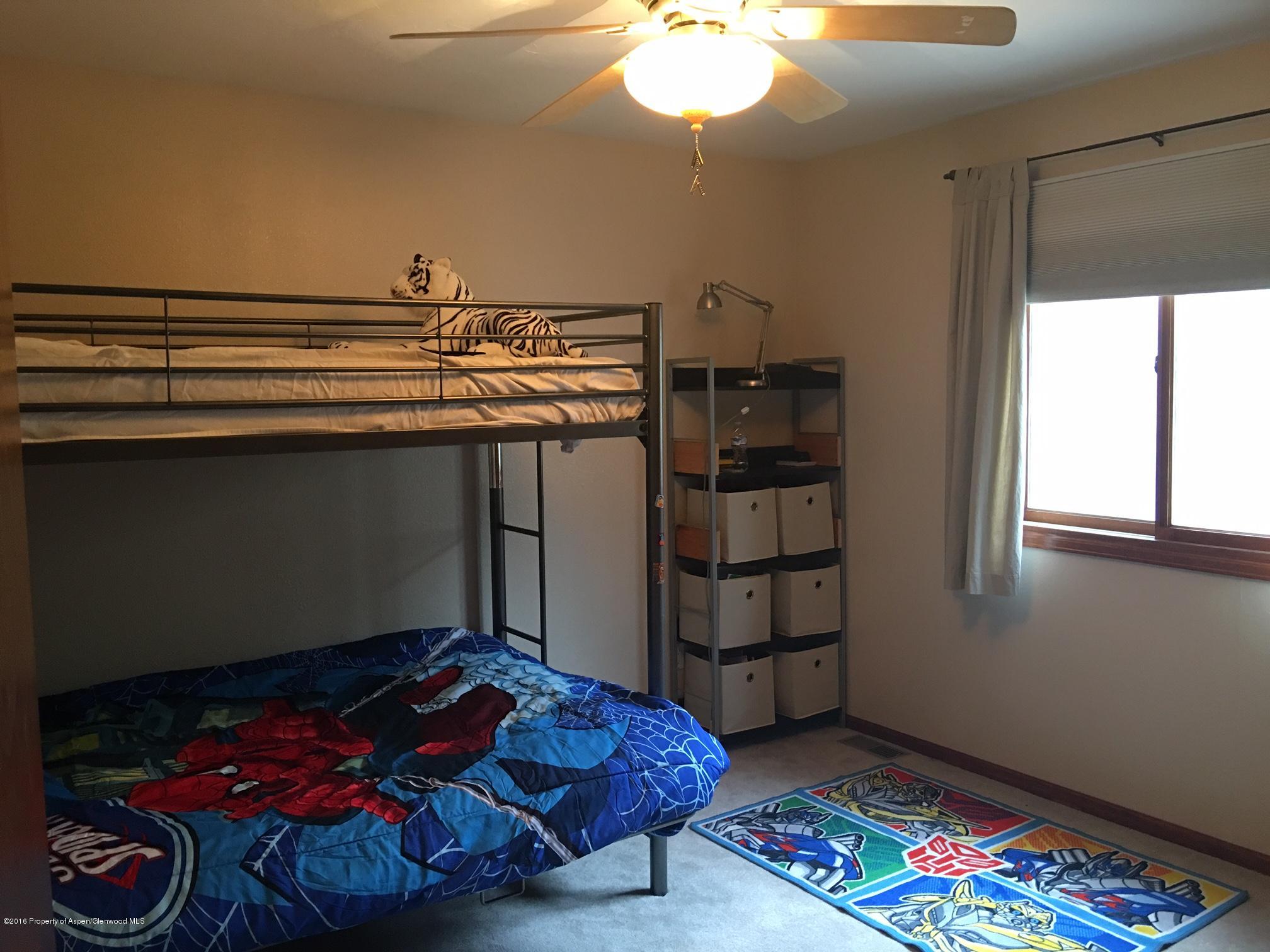 660 Moki Avenue Rifle, CO 81650 - Photo 17 of 25 a bedroom with a bed and a chandelier