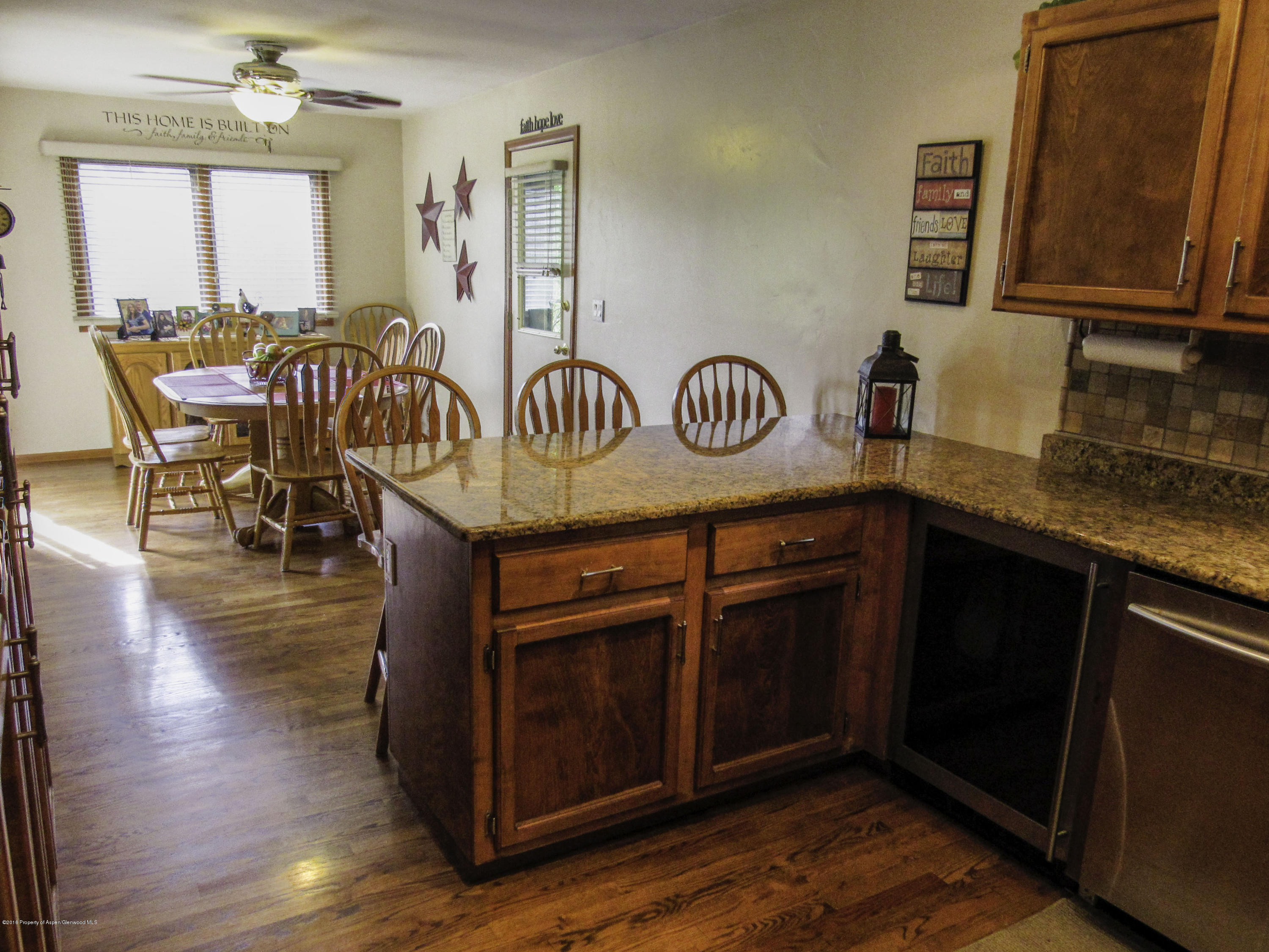 660 Moki Avenue Rifle, CO 81650 - Photo 3 of 25 a kitchen with stainless steel appliances granite countertop a table chairs and a refrigerator