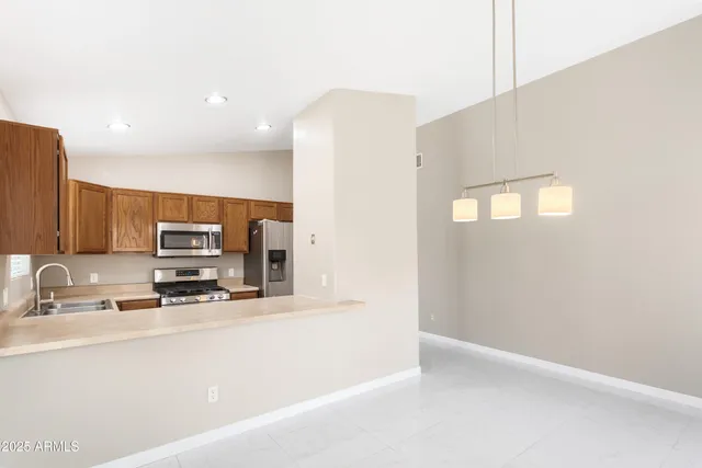 a kitchen with stainless steel appliances a sink a stove a microwave a sink and a refrigerator