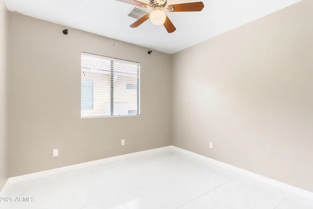 a view of a big room with windows and ceiling fan