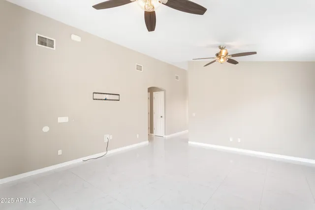 an empty room with a ceiling fan and a window