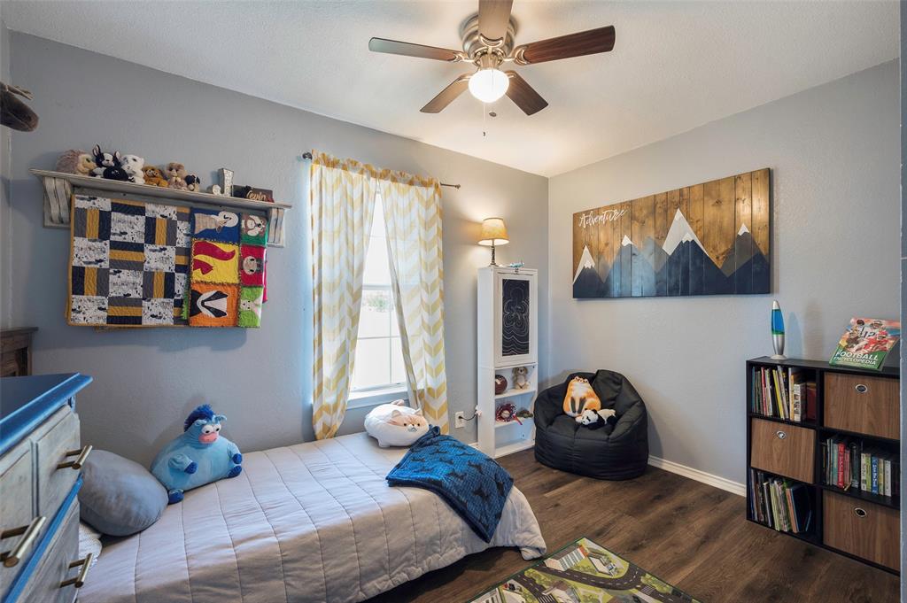 8229 East Lone Oak Road Valley View, TX 76272 - Photo 10 of 22 a bedroom with furniture and a book shelf