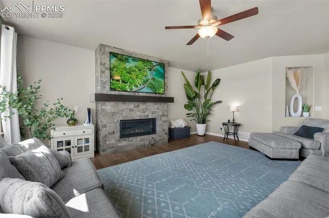 a living room with furniture a potted plant and a fireplace