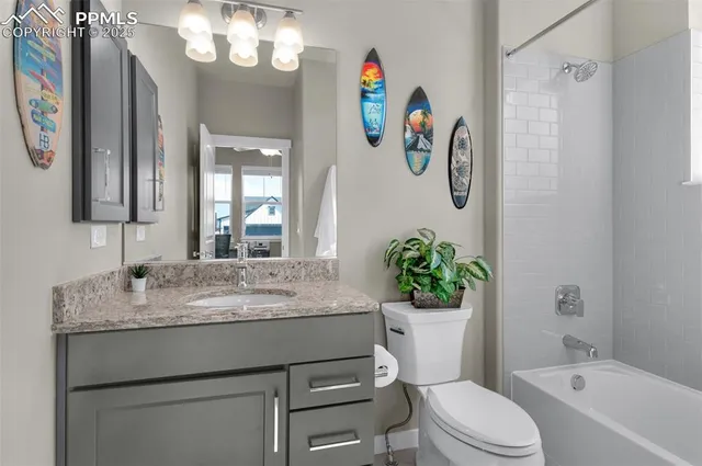 a bathroom with a granite countertop sink a toilet and a mirror