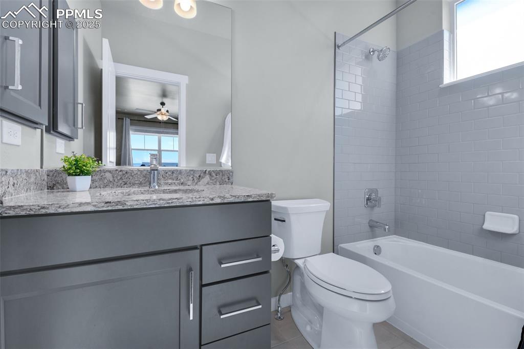 9755 Owl Perch Loop Colorado Springs, CO 80908 - Photo 30 of 50 a bathroom with a granite countertop sink a toilet and bathtub