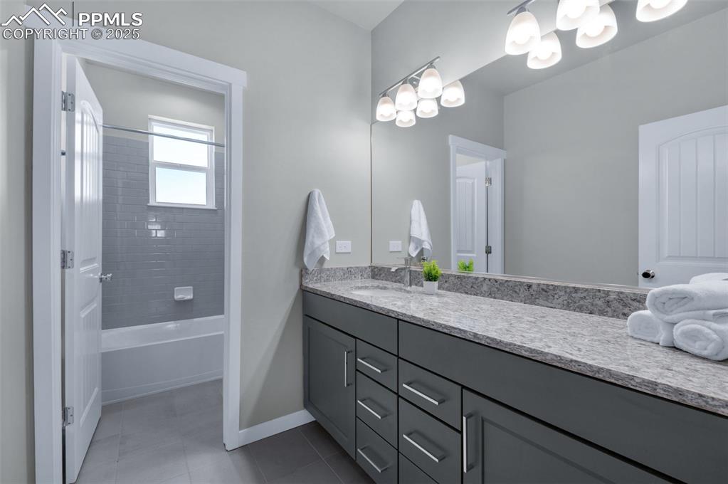 9755 Owl Perch Loop Colorado Springs, CO 80908 - Photo 32 of 50 a bathroom with a granite countertop sink a toilet and a mirror