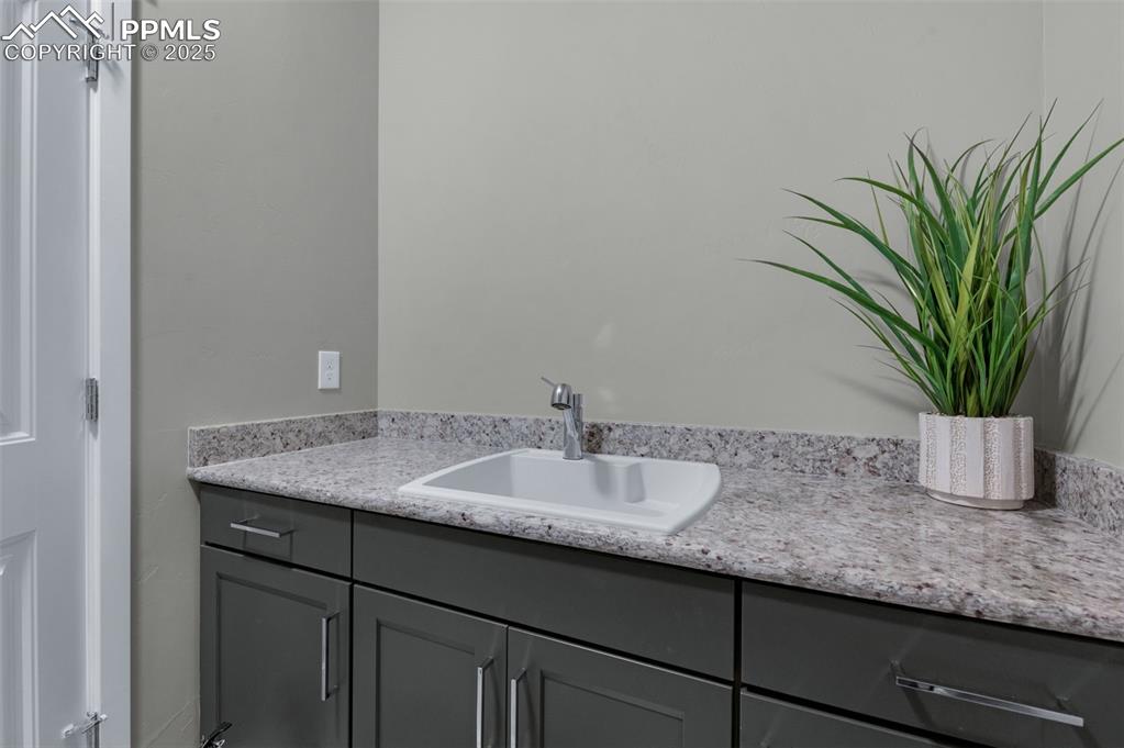 9755 Owl Perch Loop Colorado Springs, CO 80908 - Photo 34 of 50 a bathroom with a granite countertop sink a mirror and cabinets