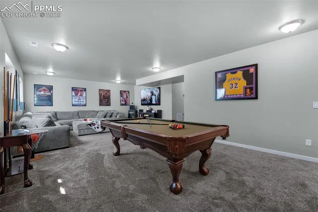 a room with furniture pool table and wall paintings