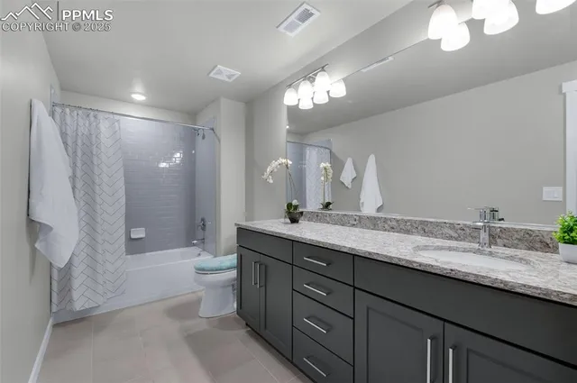 a spacious bathroom with a granite countertop sink a toilet a mirror a vanity and shower